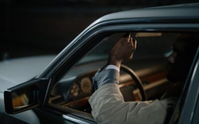 Un conducteur ajuste le rétroviseur à l'intérieur d'une voiture