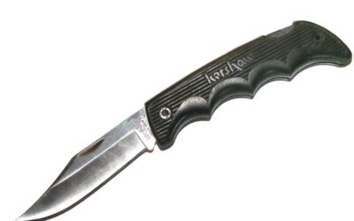 Un couteau à lame fixe noir et acier sur fond blanc